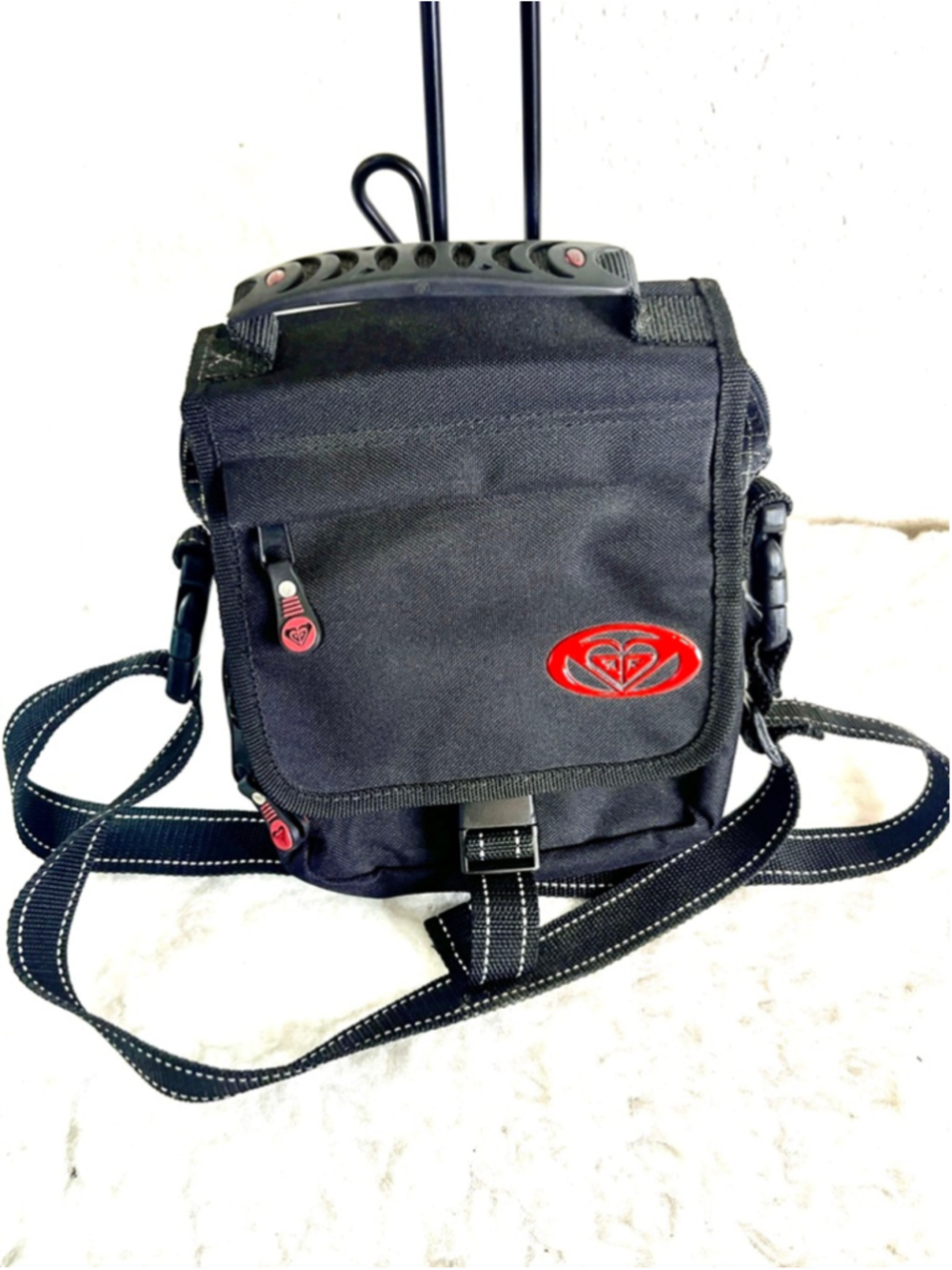Roxy Quicksilver small black messenger or crossbody bag with red logo detailing.